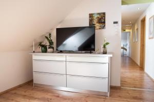 salon z telewizorem na białej komodzie w obiekcie Hetényi Apartmanház és Birtok w mieście Mecseknádasd