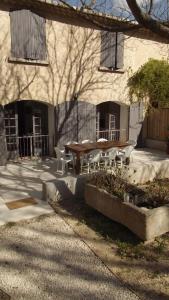 a patio with a table and chairs in front of a building at L'Oustau in Cavaillon
