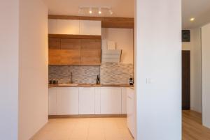 a kitchen with white cabinets and a tile floor at Central Apartment in Bucharest