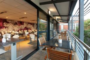 un restaurant avec un balcon meublé de tables et de chaises dans l'établissement Absolute Farenden Apartments, à Pretoria