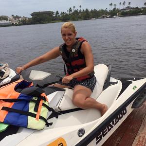 a woman sitting on a boat on the water at La Perla Bentota in Bentota