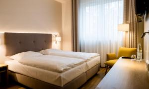 ein Schlafzimmer mit einem großen weißen Bett und einem Fenster in der Unterkunft Haus Rissen Gaestehaus in Hamburg
