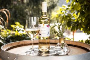 a bottle of wine and two glasses on a table at Hetényi Apartmanház és Birtok in Mecseknádasd