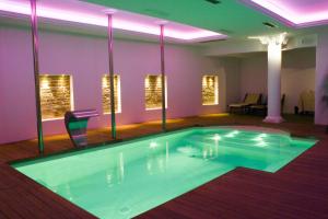 - une grande piscine dans une pièce avec des chaises et des lumières dans l'établissement Hotel Vittoria, à Pesaro
