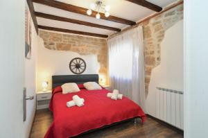 a bedroom with a red bed with white pillows at Apartment Mrgani 1814 in Mrgani