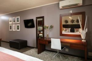 a bedroom with a desk and a mirror at Absolute Farenden Apartments in Pretoria