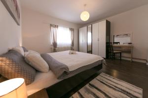 a bedroom with a bed and a desk in it at Apartments Gacka Valley in Otočac