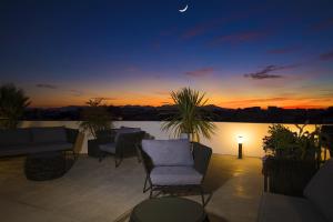 a patio with chairs and a sunset in the background at Milestone in Quartu SantʼElena