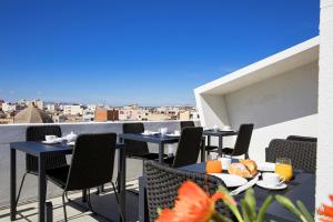 a patio with tables and chairs on a balcony at Milestone in Quartu SantʼElena