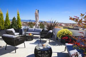 a patio with chairs and couches on a roof at Milestone in Quartu SantʼElena