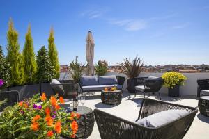 a patio with chairs and a table with flowers at Milestone in Quartu SantʼElena