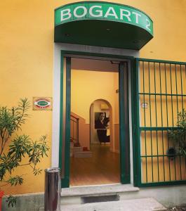 una puerta a un restaurante con un hombre de pie en él en Hotel Bogart 2 en Milán