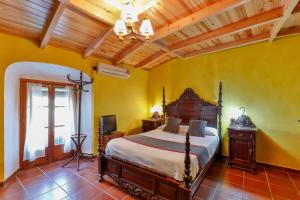 a bedroom with a bed in a room with yellow walls at Hotel Las Palmeras by Vivere Stays in Zafra