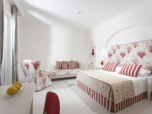 サンタニェッロにあるHotel Corallo Sorrentoの白いリビングルーム(ベッド1台、ソファ付)