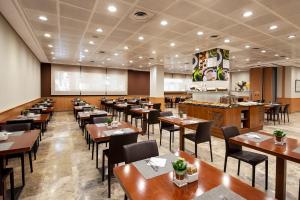 uma sala de jantar com mesas e cadeiras de madeira em Hotel Praga em Madrid