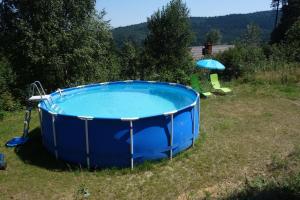 ein blauer Whirlpool in einem Garten mit Sonnenschirm in der Unterkunft Bukowinka in Krempna