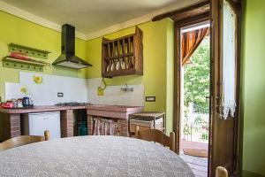a kitchen with a table and a kitchen with yellow walls at Agriturismo Il Musaccio in Barga