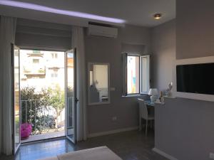 a living room with a television and a table with chairs at Residenza Corallina in Tropea