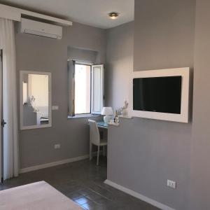 a living room with a television on a wall at Residenza Corallina in Tropea