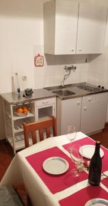 una cocina con una mesa con dos platos y una botella de vino en Sweet apartment in Pomer, en Pomer