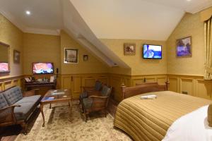 a hotel room with a bed and chairs and televisions at The Aston Tavern in Birmingham