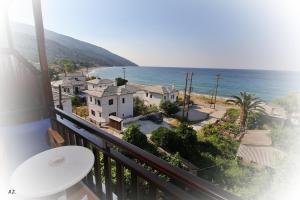 a balcony with a view of a house and the ocean at Hotel Erato in Chorefto