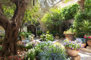 a garden filled with lots of flowers in pots at The American Colony Hotel - Small Luxury Hotels of the World in Jerusalem