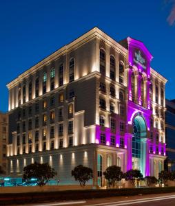 un edificio con luces púrpuras en el lateral. en Warwick Doha, en Doha