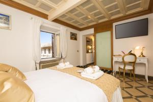 a bedroom with two beds and a desk and a television at Giuditta Suite 121 Trastevere Roma in Rome