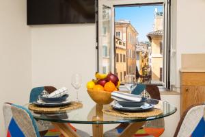 Giuditta Suite 121 Trastevere Roma في روما: طاولة غرفة الطعام مع وعاء من الفواكه عليها