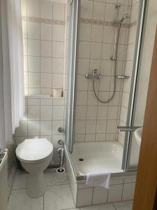 uma casa de banho com um chuveiro e um WC. em Linde Restaurant & Hotel em Trossingen