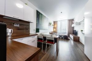 a kitchen and living room with a table and chairs at SOFT Inn in Yekaterinburg