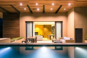 een huis met een zwembad en een woonkamer bij 2 Bedroom Luxury Pool Penthouse at ATTA in Pak Chong