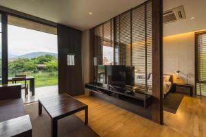 un soggiorno con televisione e una camera da letto di 2 Bedroom Luxury Pool Penthouse at ATTA a Pak Chong