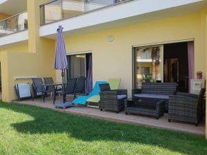 una terrazza con sedie e ombrellone su una casa di Apartamento O Jardins da Marina ad Albufeira