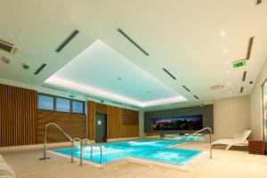 a large swimming pool in a building with a ceiling at Hotel Sport in Ivanić-Grad