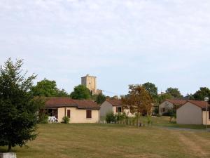 a view of a house with a tall tower in the background at Modern holiday home with dishwasher, in natural region in Moncontour-de-Poitou