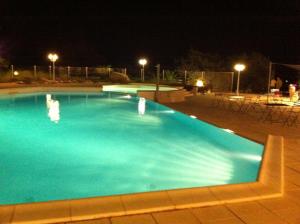 a large blue swimming pool at night at Residence Ribellinu in Pianottoli-Caldarello
