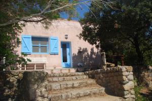 a house with a blue window and stairs at Residence Ribellinu in Pianottoli-Caldarello
