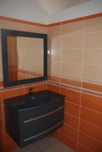 a bathroom with a black sink and a mirror at Residence Ribellinu in Pianottoli-Caldarello