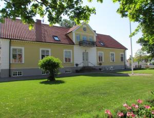 a house with a green yard with flowers at Annas Hotell in Kristianstad