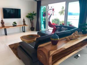 un soggiorno con divano e tavolo di D-Lux 4 bed beachfront apartment with sea view a Panwa Beach