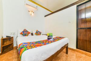 ein Schlafzimmer mit einem Bett mit einer bunten Bettdecke in der Unterkunft FabHotel Yoyo Cottage With Pool, Chapora Fort in Vagator