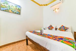 a bedroom with two beds and a painting on the wall at FabHotel Yoyo Cottage With Pool, Chapora Fort in Vagator