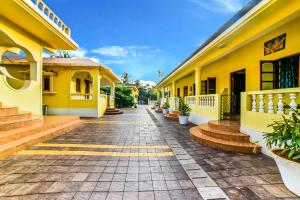 a street in a yellow building with stairs and plants at FabHotel Yoyo Cottage With Pool, Chapora Fort in Vagator