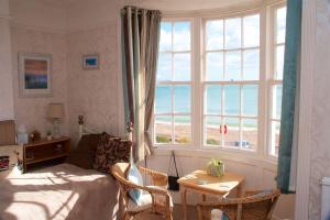 a bedroom with a bed and a view of the beach at Lyndale Guest House in Weymouth