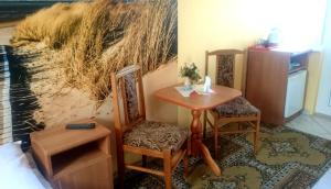 une chambre avec une table, deux chaises et un tableau dans l'établissement Dom Wczasowy Magdalena, à Władysławowo