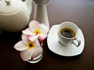 une tasse de café et une fleur sur une table dans l'établissement G9bangkok, à Bangkok