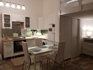 a kitchen with a table and chairs in it at Brand New Garden Flat / Free Parking in Budapest