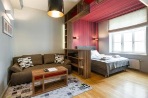 een woonkamer met een bank en een bed bij Yourplace Biskupia Old Town Apartments in Krakau